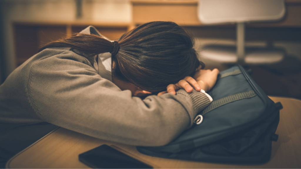 机に伏せる女性